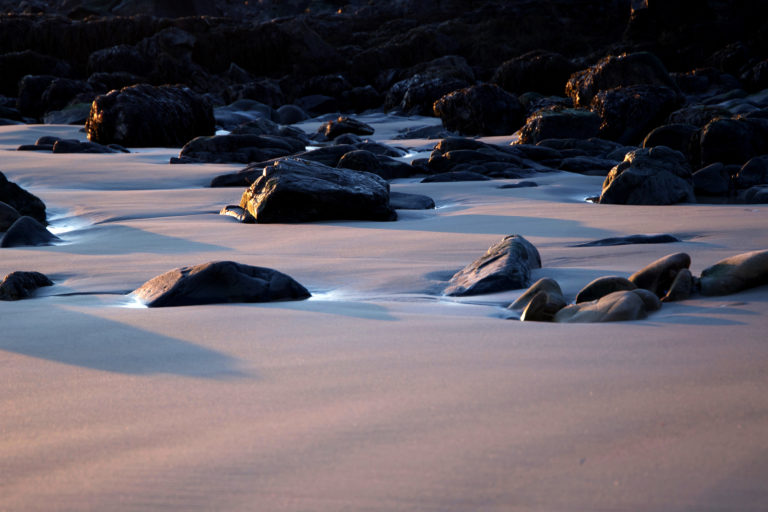 Shadowed Rocks on Smooth Sand Beach