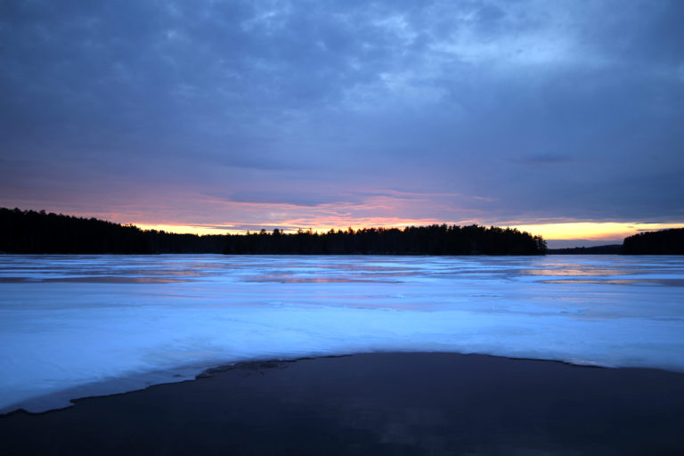 Sunset on the Horizon of Frozen Lake