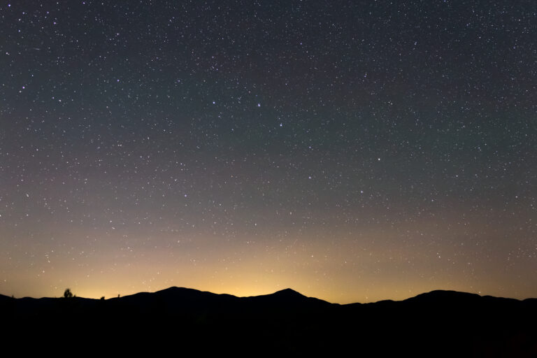 Starry Night Sky and Mountain Silhouettes
