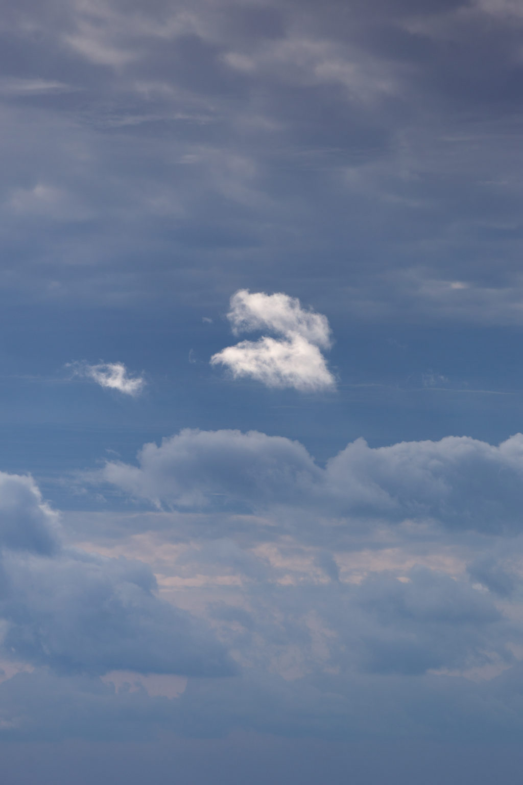 Small Bright Cloud Against Muted Clouds