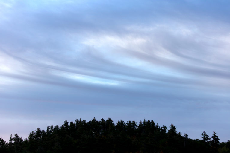Swirling Clouds Over Hill